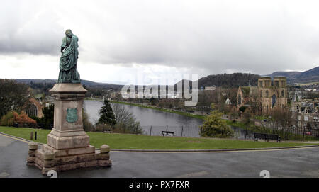 A statue of Flora MacDonald overlooks the city of Inverness and the River Ness from Inverness castle where her statue sits, in Scotland. Inverness cathedral is on the right of the photograph. Stock Photo