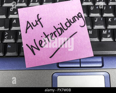 Memo note on notebook, on further education Stock Photo