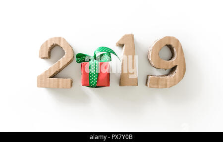 2019, handmade 3D numbers and gift box made of reused cardboard paper, on white background. Stock Photo