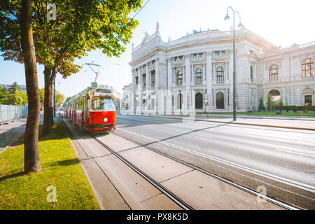 Famous Wiener Ringstrasse with historic Burgtheater (Imperial Court Theatre) and traditional red electric tram at sunrise, Vienna, Austria Stock Photo