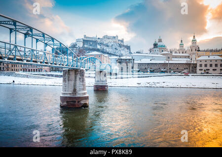 Panoramic view of the famous old town of Salzburg with historic Mozartsteg crossing Salzach river in beautiful golden evening light at sunset with clo Stock Photo