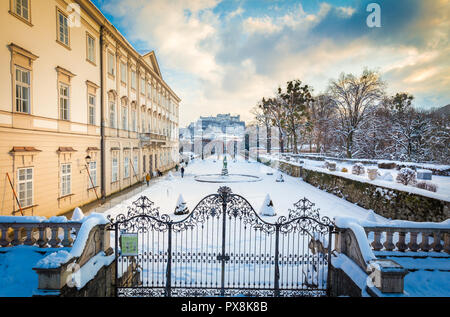 Classic view of famous Mirabell Gardens with historic Hohensalzburg Fortress in the background in scenic golden evening light at sunset on a beautiful Stock Photo