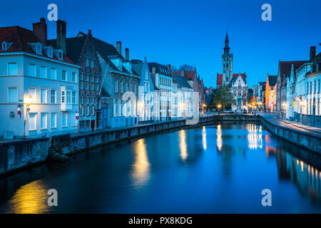 Beautiful panoramic view of famous Spiegelrei canal with famous Poortersloge and Jan van Eyck square in the background illuminated during blue hour Stock Photo