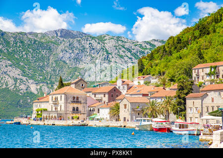 Scenic panorama view of the historic town of Perast at famous Bay of Kotor on a beautiful sunny day with blue sky and clouds in summer, Montenegro Stock Photo