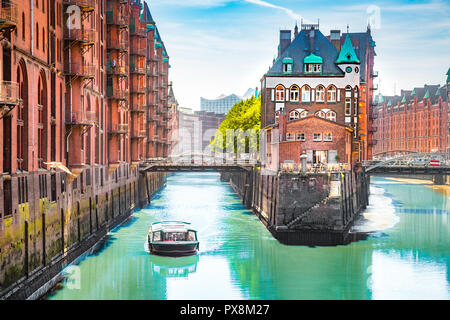 Classic view of famous Hamburg Speicherstadt warehouse district with sightseeing tour boat on a sunny day in summer, Hamburg, Germany Stock Photo