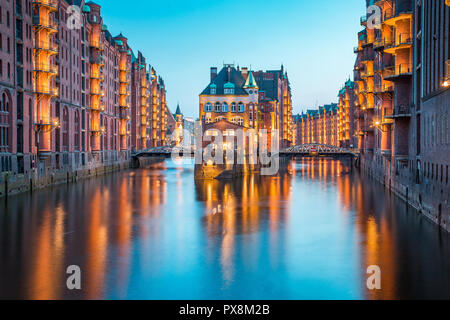 Classic view of famous Speicherstadt warehouse district, a UNESCO World Heritage Site since 2015, illuminated in beautiful post sunset twilight at dus Stock Photo