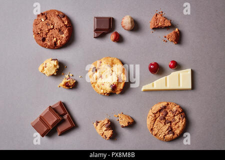 Different cookies with chocolate chips, hazelnuts and cranberries on grey background, top view Stock Photo