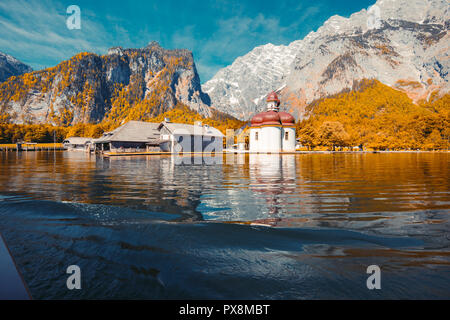 Classic panoramic view of Lake Konigssee with world famous Sankt Bartholomae pilgrimage church and Watzmann mountain on a beautiful sunny day in fall, Stock Photo