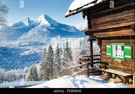 Beautiful view of scenic winter wonderland mountain scenery with rustic wooden mountain cabin in  in the Alps Stock Photo