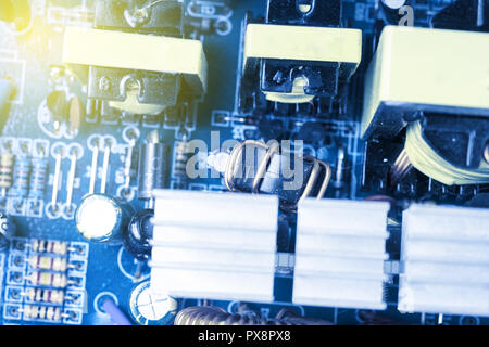 Microchip, capacitors, resistors on a blue computer board close-up. Industrial background. Stock Photo