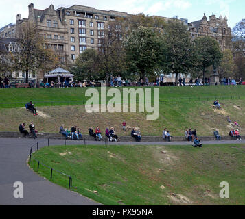 Edinburgh, Scotland, UK. 20th Oct, 2018.  Also, people can be seen relaxing in the gardens with some of the stumps of the recently felled 52 trees which some of the locals have branded 'An Absolut Disgrace', this is part of landscaping works and an extension at Scottish National Gallery backed by the Edinburgh council. Stock Photo