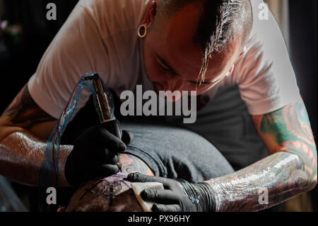 Skibbereen, West Cork, Ireland. 20th Oct, 2018. A tattooist tattos the back of a head during the tattoo show. The show has been attended by many tattooists from across Ireland and the North. The event finishes tomorrow. Credit: Andy Gibson/Alamy Live News. Stock Photo