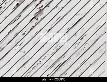 the diagonal line of the barn made of boards painted with white paint, part of the paint began to peel and slice from the tree Stock Photo