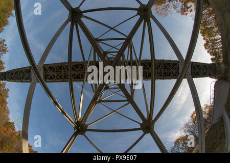 A bridge over a river built from a truss. Bridge, truss joined by rivets in old technology on the river. Winter campery. Stock Photo