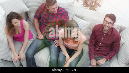 view from the top. triumphant group of friends laughing while sitting on the couch in the living room Stock Photo