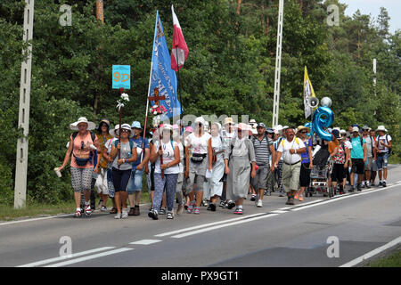 Group of pilgrims walk on the road during pilgrimage to the Monastery of Jasna Gora in Czestochowa, Poland for the annual feast of Assumption of Mary. Stock Photo