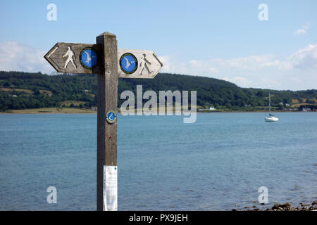 Wooden Signpost for the Isle of Anglesey Coastal Path in Red Wharf Bay, Wales, UK. Stock Photo