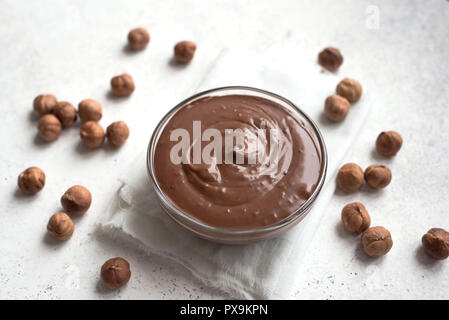 Chocolate Hazelnut Spread on white background, top view, copy space. Homemade chocolate spread with hazelnuts. Stock Photo