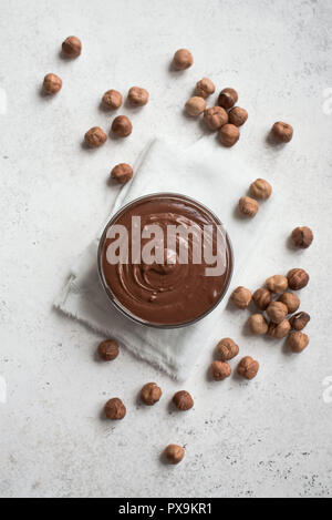 Chocolate Hazelnut Spread on white background, top view, copy space. Homemade chocolate spread with hazelnuts. Stock Photo