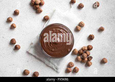 Chocolate Hazelnut Spread on white background, top view, copy space. Homemade chocolate spread with hazelnuts. Stock Photo