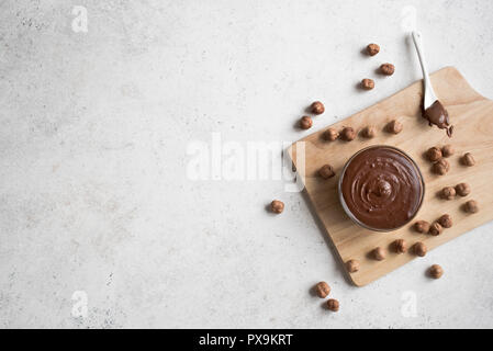 Chocolate Hazelnut Spread on white background, top view, copy space. Homemade chocolate spread with hazelnuts. Stock Photo
