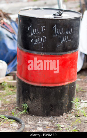 A barrel of 200 liters with hydraulic oil stands on the ground. Summer, sunny day. Russia. Stock Photo