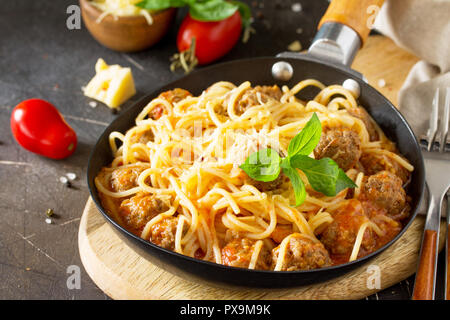 Spaghetti with Meatballs with Tomato Sauce and Parmesan Cheese on a dark stone or concrete background. Stock Photo