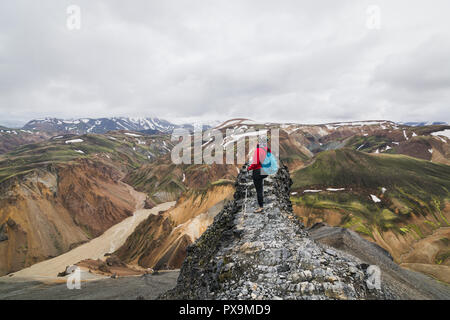 Woman hiking in the colourful mountains of Landmannalaugar national park, Iceland. Stock Photo