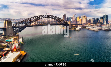 Steel arch of the Sydney harbour bridge over Sydney harbour between North Shore and the city CBD landmarks around the Rocks and Barangaroo. Stock Photo