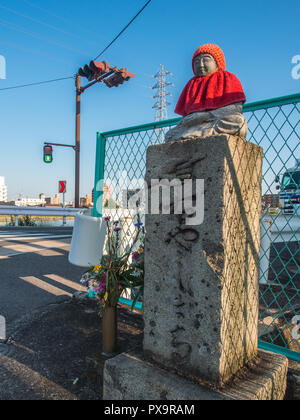 Hyoseki stone guide post,  with buddha statue,  roadside shrine, busy city street, Takamatsu, Kagawa, Japan Stock Photo