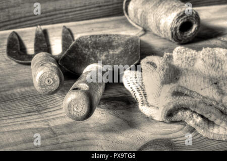 Garden fork and trowel tools with string and gloves on a wooden background with toning Stock Photo