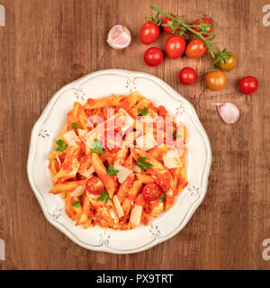 Penne pasta with tomato sauce, chicken, and cheese, with ingredients and a place for text Stock Photo