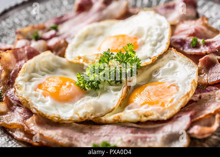 Close-up roasted bacon and egg with herbs on plate. Stock Photo