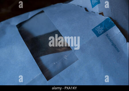 The dreaded blue envelope indicating collection of Dutch taxes Nederland income is due to Tax Office, belastingdienst Stock Photo