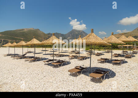 Umbrellas on the Borsh Beach in Albania. Stony beach on the Adriatic Sea. Stock Photo