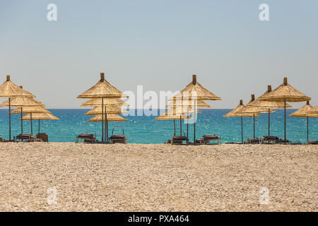 Umbrellas on the Borsh Beach in Albania. Stony beach on the Adriatic Sea. Stock Photo
