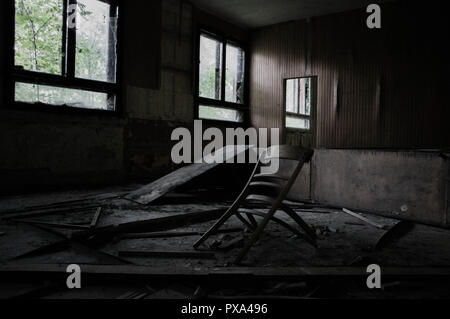 Broken furnitures in an abandoned building in a dirty room Stock Photo