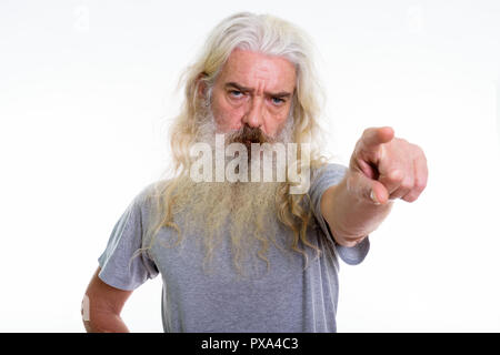 Studio shot of angry senior bearded man pointing at distance tow Stock Photo