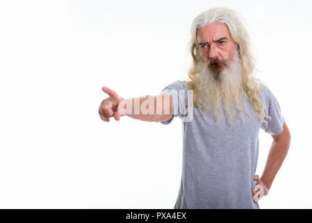 Studio shot of senior bearded man looking and pointing to the si Stock Photo