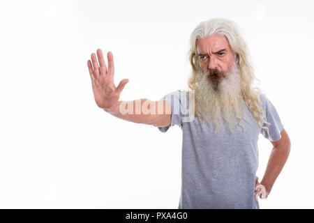 Studio shot of senior bearded man showing stop hand sign to the  Stock Photo