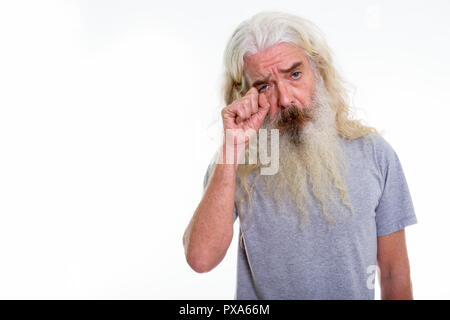 Studio shot of senior bearded man looking sad while crying Stock Photo