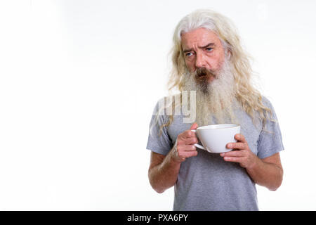 Studio shot of stressed senior bearded man looking tired while h Stock Photo