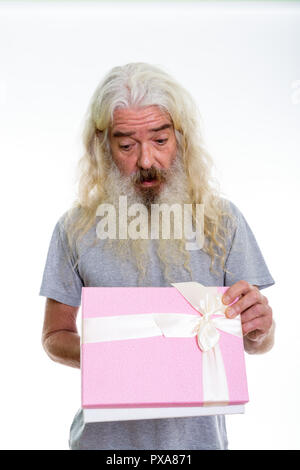 Studio shot of surprised senior bearded man opening gift box rea Stock Photo