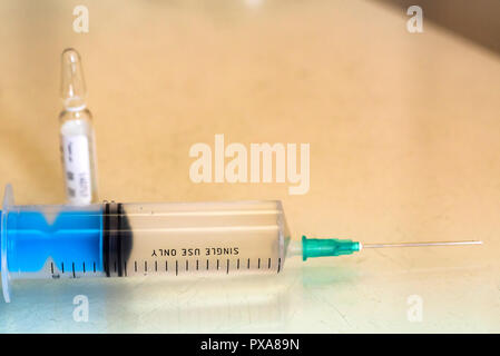 Syringe and a vial with medication on table close Stock Photo