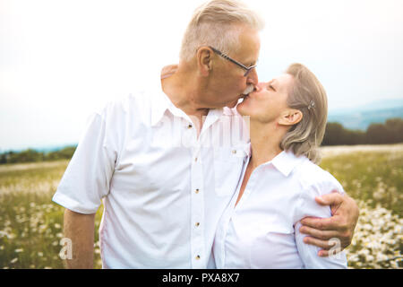A Senior couple outdoors in a daisy field Stock Photo