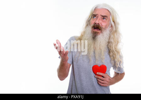 Studio shot of angry senior bearded man looking up and holding r Stock Photo