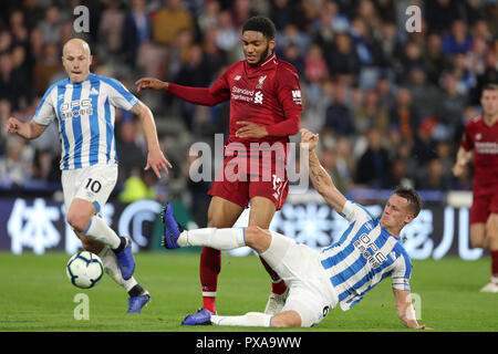 Liverpool's Joe Gomez (centre) and Huddersfield Town's Jonathan Hogg battle for the ball during the Premier League match at the John Smith's Stadium, Huddersfield. Stock Photo