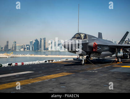 181014-N-AT135-1003 DOHA, Qatar (Oct. 14, 2018) An F-35B Lightning II attached to the “Avengers” of Marine Fighter Attack Squadron (VMFA) 211 is chocked and chained on the flight deck as the Wasp-class amphibious assault ship USS Essex (LHD 2) arrives in Doha, Qatar. Essex is a flexible, and persistent Navy-Marine Corps team deployed to the U.S. 5th Fleet area of operation in support of naval operations to ensure maritime stability and security in the Central Region, connecting the Mediterranean and the Pacific through the western Indian Ocean and three strategic choke points. (U.S. Navy photo Stock Photo