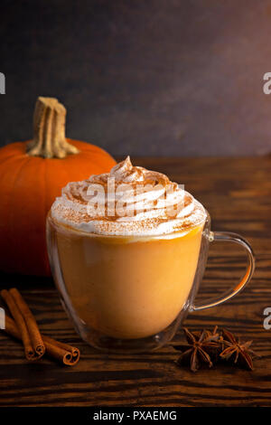 A Pumpkin Spice Latte in a Clear Mug on a Wooden Table Stock Photo