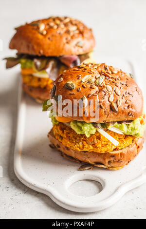 Vegan pumpkin burgers on white background. Vegetable burgers, avocado, vegetables and buns. Stock Photo